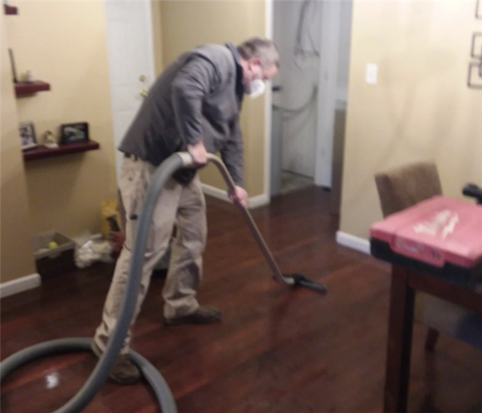 SERVPRO of St. Charles Owner Dan Wessell extracting water from a wood floor